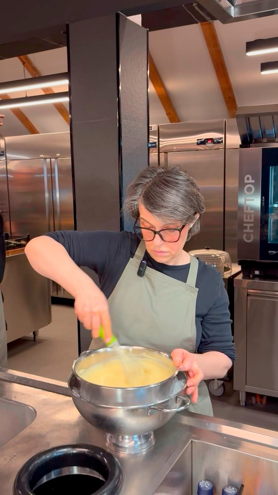 A pastry chef whisking cream in a professional kitchen